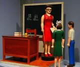 Model of a teacher and two students in a school house